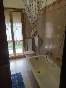 baño con bañera, aseo y ventana en Casa Totti, 