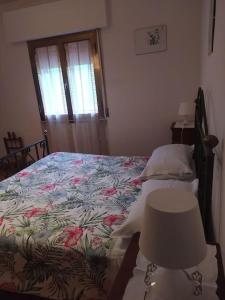 1 dormitorio con cama, lámpara y ventana en Casa Totti, 