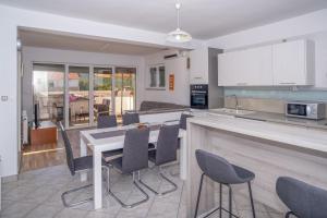 a kitchen and living room with a table and chairs at Apartment Bura in Šibenik