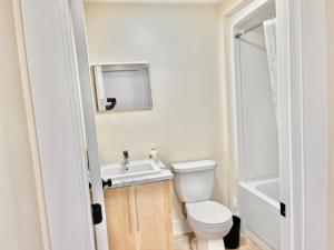 a bathroom with a toilet and a sink and a mirror at Cozy Newly built apartment airport location in Dieppe