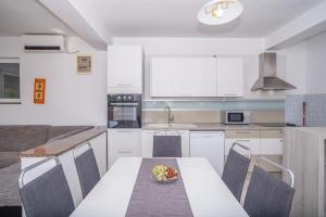 a kitchen with a table with a bowl of fruit on it at Apartment Bura in Šibenik