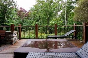 a wooden deck with a bench and a pond at Ski In/Ski Out Luxury Tremblant Chalet in Mont-Tremblant