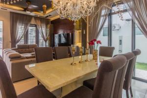 Varnen Cozy Haven في بوكيت ميرتاجام: غرفة طعام مع طاولة وأريكة