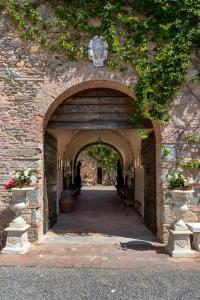 einen Eingang zu einem Steingebäude mit Torbogen in der Unterkunft Villa Scorzi - Relais de Charme in Calci