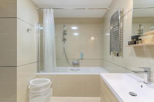 La salle de bains est pourvue d'une baignoire, d'une douche et d'un lavabo. dans l'établissement B41 Apartment Poiana Brasov, à Poiana Brasov