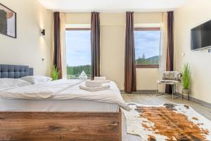 a bedroom with a large bed and a large window at B41 Apartment Poiana Brasov in Poiana Brasov
