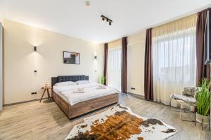 a bedroom with a large bed and a chair at B41 Apartment Poiana Brasov in Poiana Brasov