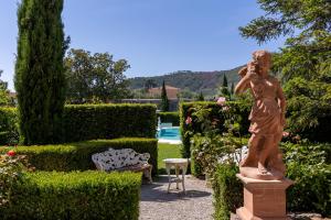 eine Statue einer Frau, die in einem Garten steht in der Unterkunft Villa Scorzi - Relais de Charme in Calci