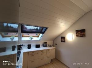 eine Küche im Dachgeschoss mit zwei Fenstern und einer Theke in der Unterkunft Lieblingsort in Freudenstadt