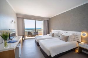 a hotel room with two beds and a large window at Arribas Sintra Hotel in Sintra