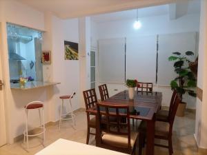 uma sala de jantar e cozinha com mesa e cadeiras em Ponta da Praia amplo 3dorm 3ban frente ao mar em Santos