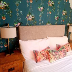 a bedroom with a bed with flowers on the wall at Foxhollow House in Blarney