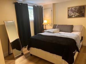 a bedroom with a bed and a mirror and a window at Cozy Newly built apartment airport location in Dieppe