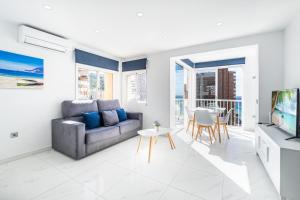 een woonkamer met een bank en een tafel bij Don Paco 12-B Deluxe Apartment Levante Beach in Benidorm