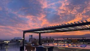 um terraço no último piso com uma piscina e um pôr-do-sol em Mass Paradise Hotel em Aqaba