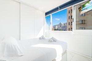 een witte badkamer met een wastafel en een raam bij Don Paco 12-B Deluxe Apartment Levante Beach in Benidorm +29 foto's
