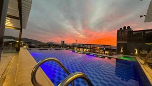 a swimming pool on top of a building with a sunset at Mass Paradise Hotel in Aqaba