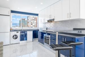 een blauwe en witte keuken met een wasmachine en droger bij Don Paco 12-B Deluxe Apartment Levante Beach in Benidorm
