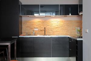 a kitchen with black cabinets and a sink at P&O Serviced Apartments GDANSKI STATION in Warsaw