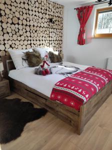 a bedroom with a bed with a red and white blanket at Domek Pod Tatrami Kościelisko in Kościelisko
