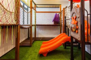 a childrens play room with an orange slide at Varnen Cozy Haven - EVCharger in Bukit Mertajam