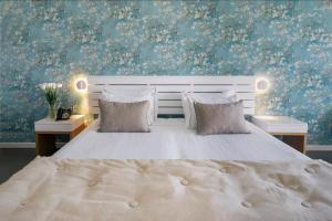 a bedroom with a large white bed with blue wallpaper at Arribas Sintra Hotel in Sintra