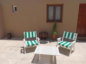 2 sillas verdes y blancas y una mesa en El Tonel en Cafayate