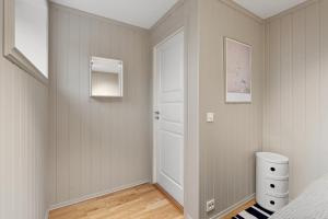 a bedroom with a white door and a bed at Cozy elegant 2bedroom apt w/parking and nice view in Tromsø