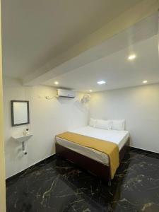a small bedroom with a bed and a sink at MKS Homes in Tirukkadaiyūr