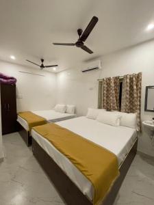 a bedroom with two beds and a ceiling fan at MKS Homes in Tirukkadaiyūr
