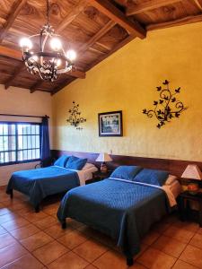 um quarto com 2 camas e um lustre em El Tejado em Suchitoto