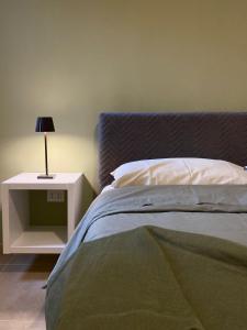 una camera con letto e comodino con lampada di Domus Regia - Centro Storico a Caserta
