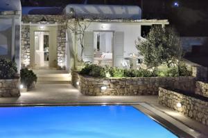 a swimming pool in front of a house at night at Villa Mon Rêve "5-minute walk beach, restaurants, supermarket" in Mikonos