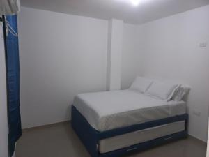 een klein bed in een kamer met een witte muur bij Hotel Samark Valledupar in Valledupar