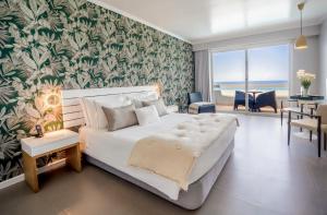 a bedroom with a large bed and a dining room at Arribas Sintra Hotel in Sintra