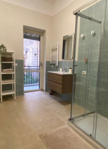 bagno con lavandino e doccia in vetro di Domus Regia - Centro Storico a Caserta