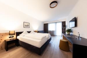 カルテルベッロにあるHotel Sandの大型ベッドとシンクが備わるホテルルームです。