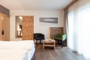 a bedroom with a bed and a desk and a chair at Hotel Sand in Kastelbell-Tschars