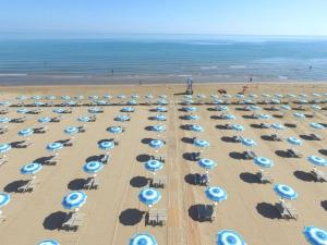 una vista panoramica su una spiaggia con ombrelloni blu e bianchi di Baia Degli Aranci Suite & Apartments a Vieste