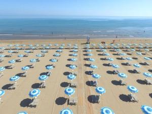 ヴィエステにあるBaia Degli Aranci Suite & Apartmentsの青と白の傘が備わる海辺の景色