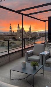 - un balcon offrant une vue sur la ville au coucher du soleil dans l'établissement Ático mejores vistas al Pilar jacuzzi y garaje, à Saragosse