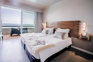 a hotel room with two beds and a large window at Arribas Sintra Hotel in Sintra