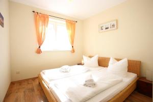 ein großes weißes Bett in einem Zimmer mit Fenster in der Unterkunft Ferienhaus Puschmann - FeWo 03 in Zinnowitz