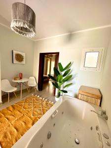 uma casa de banho com uma banheira, uma mesa e uma sala de jantar em Babushka Boutique Hotel-Dahab em Dahab
