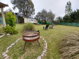 a yard with two chairs and a fire pit at Las Nativas de Areco in San Antonio de Areco