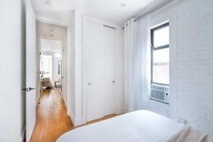 Habitación blanca con cama y ventana en 1290-13 Newly Renovated 2 Bedrooms in UES, en Nueva York