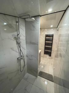 ein Bad mit einer Dusche und einer Glastür in der Unterkunft Apartment Secret room Paris-Stade de France in Aubervilliers