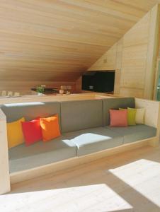 a couch with colorful pillows on it in a room at Tabia' Stelo Fiorito in Santo Stefano di Cadore