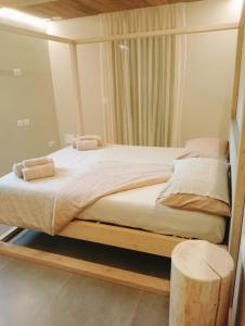 1 cama con marco de madera en una habitación en Tabia' Stelo Fiorito, en Santo Stefano di Cadore