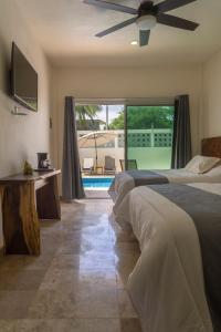 - une chambre avec 2 lits et un ventilateur de plafond dans l'établissement PETRAS HOTEL, à Brisas de Zicatela
